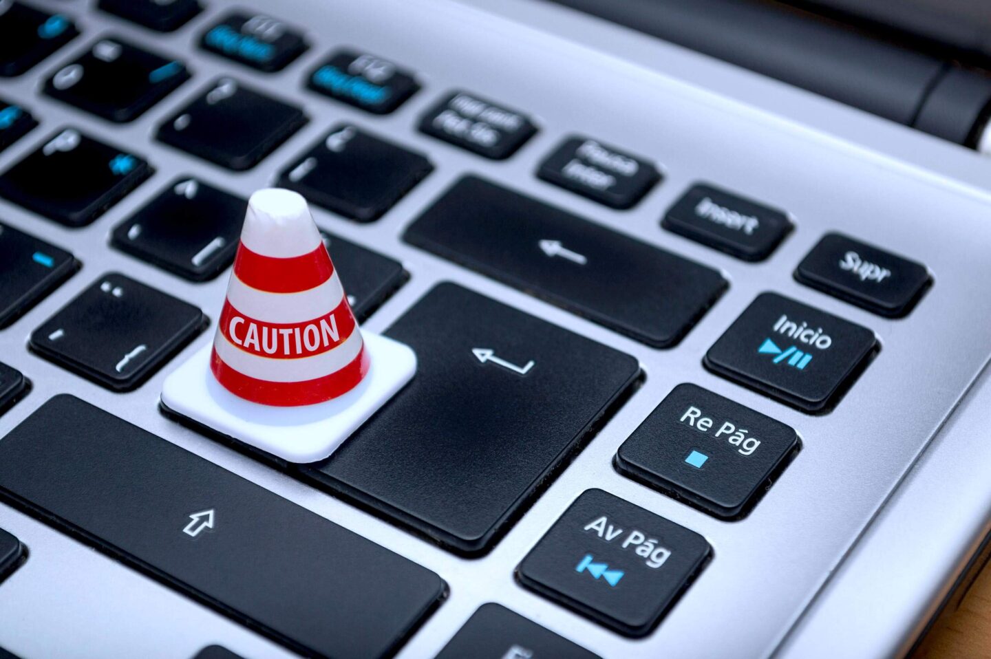 Computertastatur auf der ein Hütchen mit CAUTION Aufdruck steht
